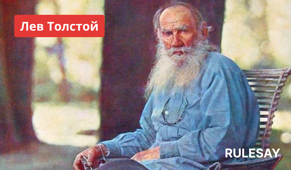Лев Николаевич Толстой сидит на деревянном стуле на лоне природы