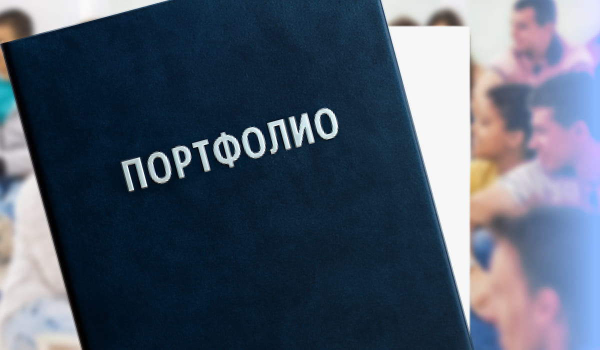Тёмно-синяя папка с надписью "Портфолио" на фоне размытых людей, концепция портфолио абитуриента.