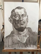 Портрет выполнен углём на бумаге, передавая глубину и текстуру лица мастерскими штрихами и растушёвкой.
Использованы контрасты света и тени, чтобы подчеркнуть объём и эмоциональную выразительность образа.